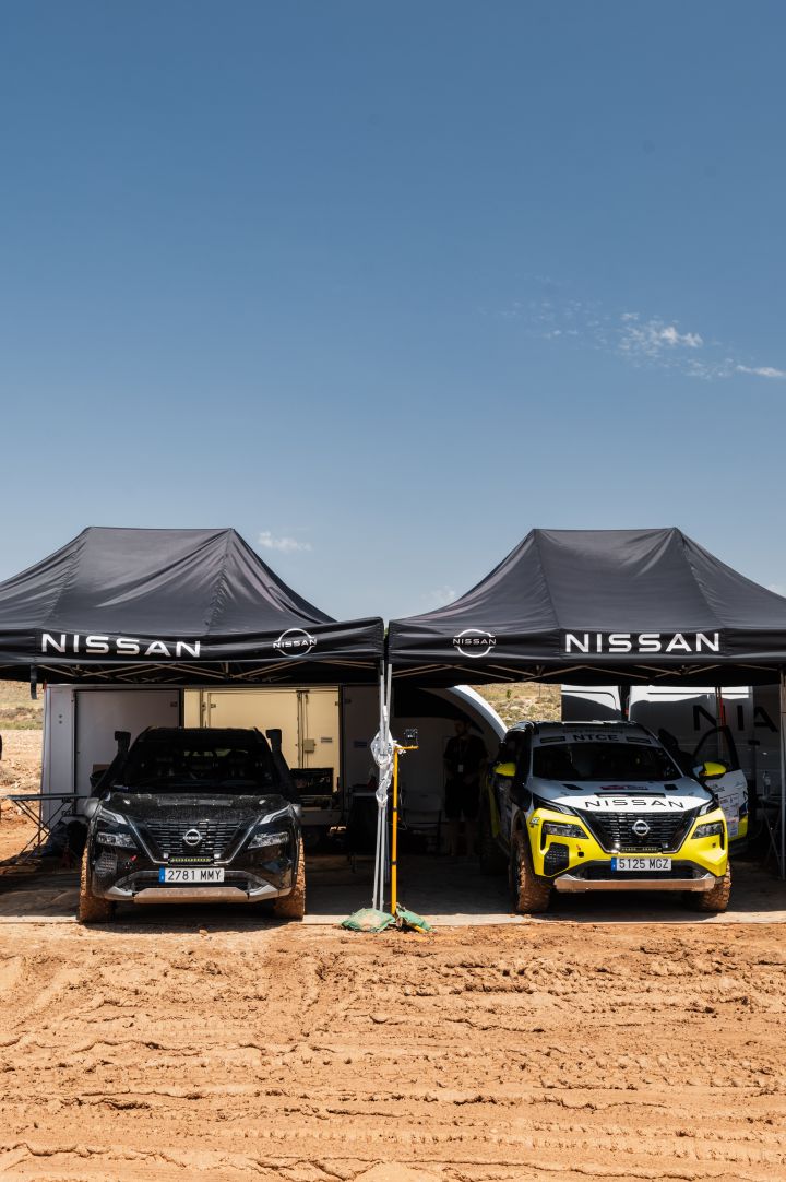 Zwei Nissan X‑Trail parken unter zwei Nissan Pavillons auf sandigem Boden, der rechte ist das Rennfahrzeug für die Baja Aragon Rallye 2024