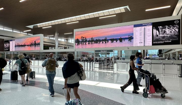 Travelers walking near the security gates in an airport.