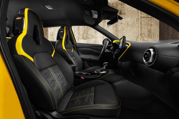 Innenraum des Nissan Juke mit seitlichem Blick auf die vorderen Sitze, schwarz mit gelben Akzenten