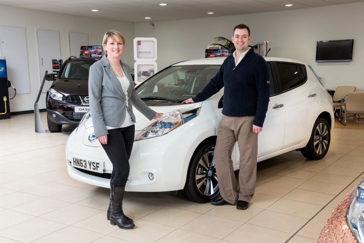 Brett Garner and his wife in front of white Nissan LEAF