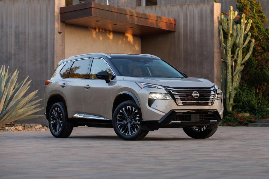 A gray 2024 Nissan Rogue parked in front of a house.