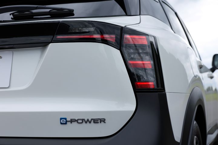 白系キックスのリア部のクローズアップ。「e‑POWER」バッジとテールランプが確認でき、車両は右向きに配置されている。
