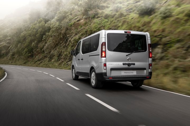 Nissan Primastar vista três quartos em estrada, com vegetação de fundo