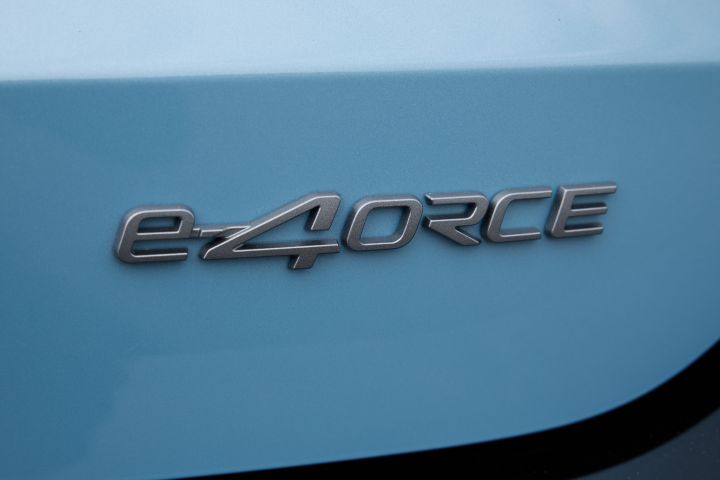 青みがかったキックスのボディに配置された「e‑4ORCE」エンブレムのクローズアップ。ロゴは水平に配置され、塗装面の滑らかな質感が際立つ。