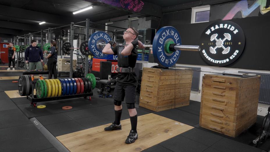 A young person lifts a barbell in the Weights and Cakes gym in Sunderland