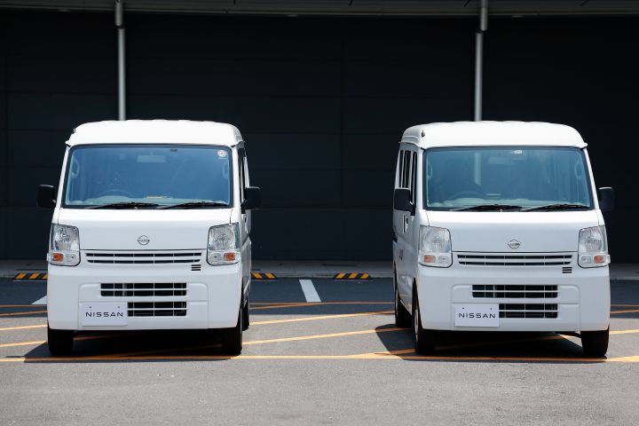 実証実験車のNV100が羽田空港の駐車場に停車している様子。背景は黒。