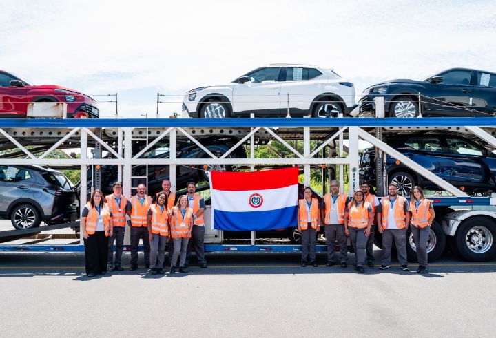 Trabalhadores da Nissan seguram uma bandeira do Paraguai à frente de uma carreta carregada com o Nissan Kait