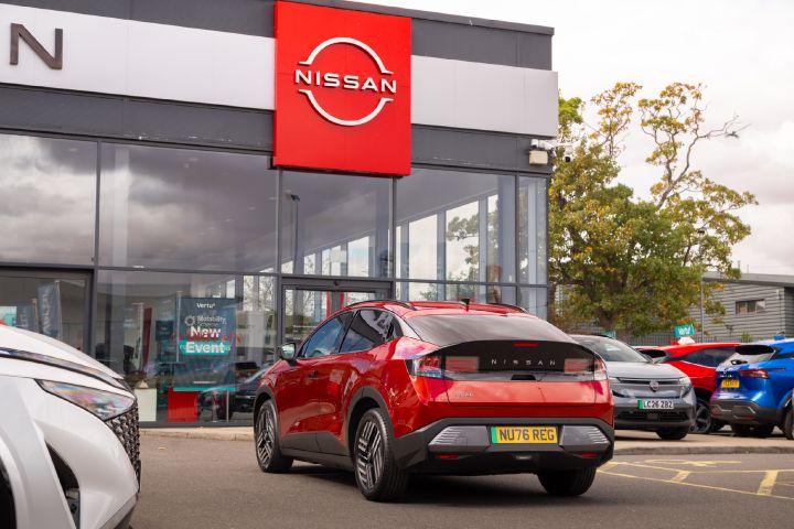 Rear view of a red Nissan LEAF outside a Nissan showroom