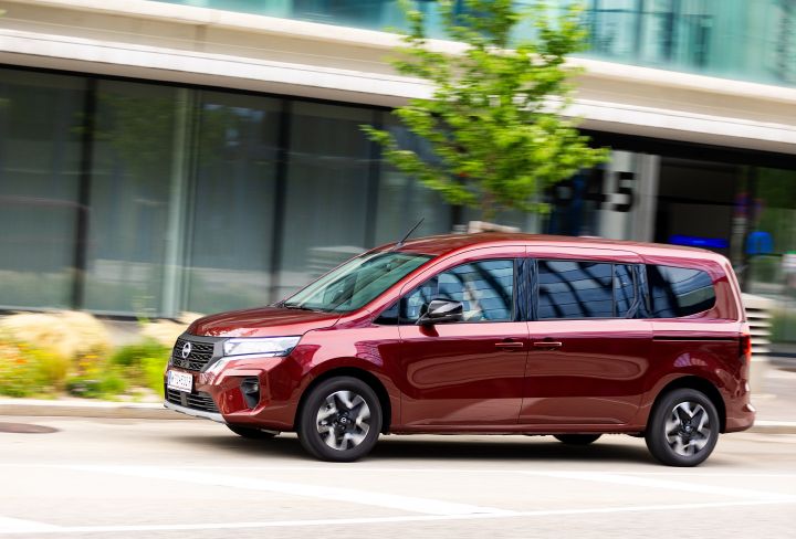 Seitliche Fahraufnahme eines roten Nissan Townstar Evalia Kombi in der Stadt