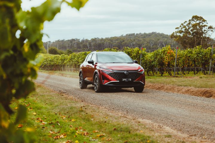 A 2026 Qashqai e‑POWER model driving past a vineyard.