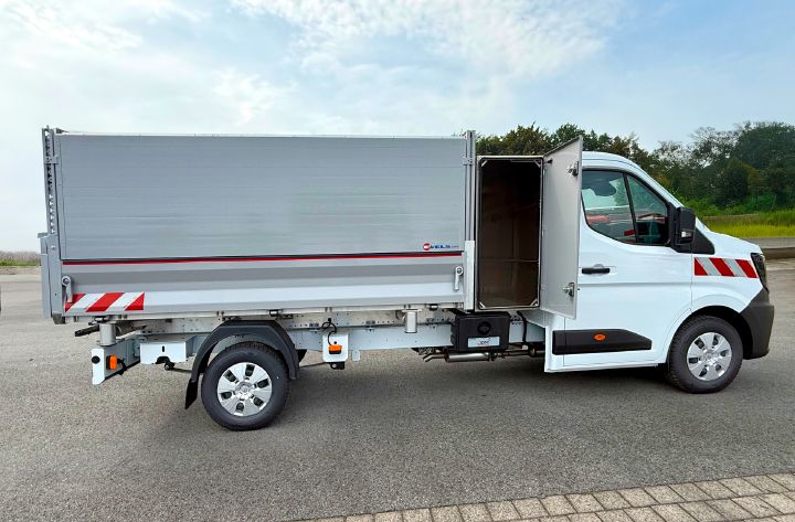 Seitenansicht vom Nissan Interstar Drei-Seiten-Kipper mit geschlossenem Aufbau und geöffneter Türe zu einem Kasten hinter dem Fahrerhaus