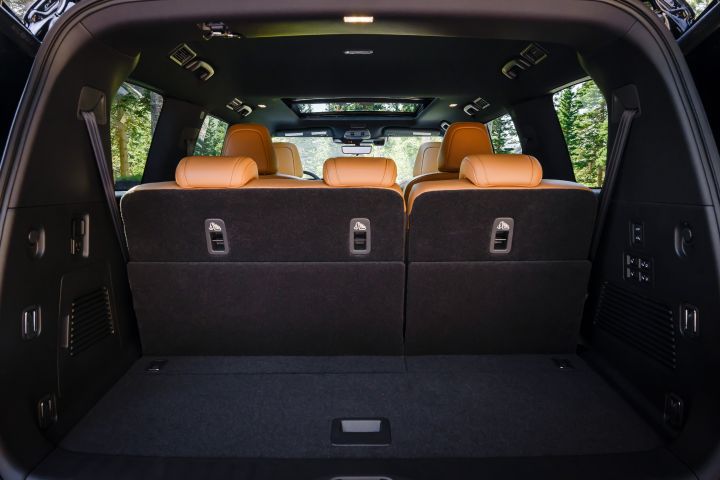View of the interior from the open hatch back of a 2025 Nissan Armada, the cargo space and third row seats can be seen.