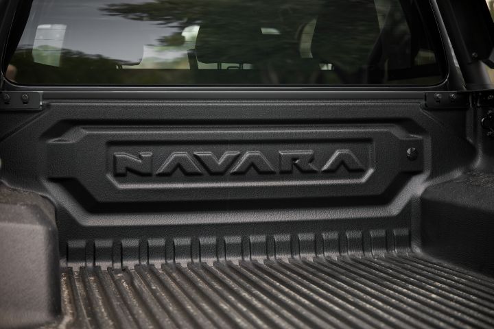 2026 Nissan Navara PRO-4X finished in Boulder Grey focusing on the tub bulkhead with embossed NAVARA branding and ribbed liner floor.