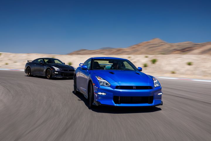 Two Nissan 2024 GT‑R Special Editions driving around a corner on a race track with mountains in the background