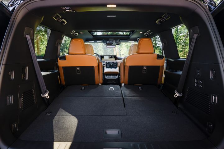 View of the interior from the open hatch back of a 2025 Nissan Armada, the black cargo space and rear seats can be seen.