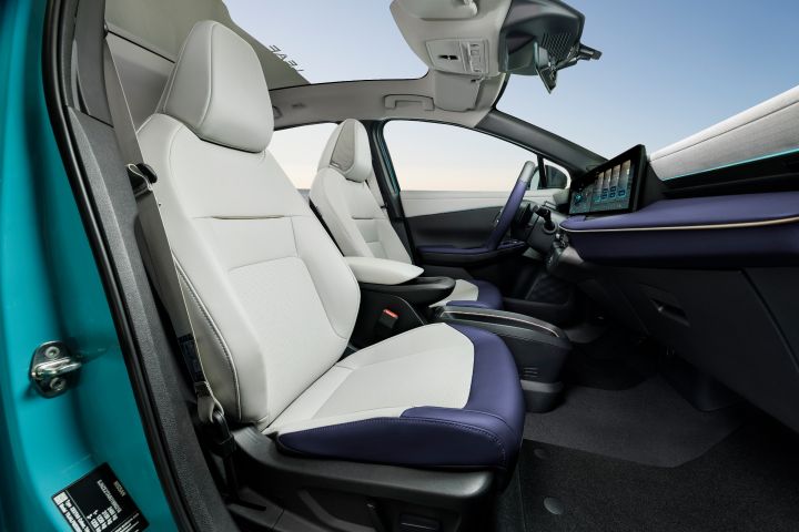 Blick durch die Beifahrertür auf die hellen Vordersitze mit blauen Akzenten im Inneren des Nissan LEAF