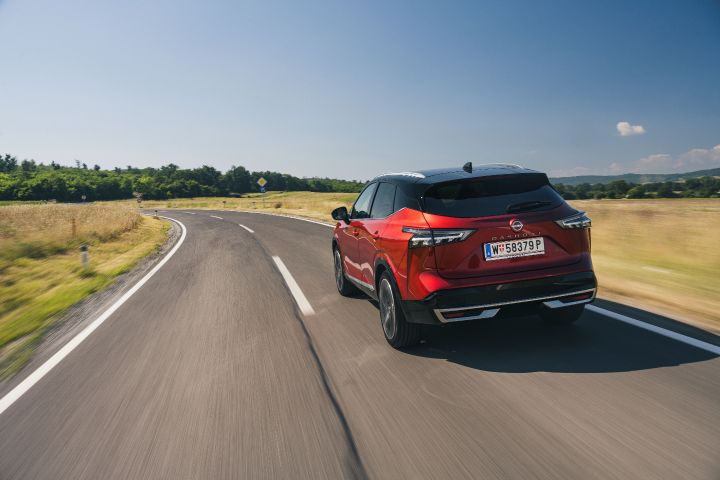 Heckaufnahme eines fahrenden Nissan Qashqai in Fuji Sunset Red