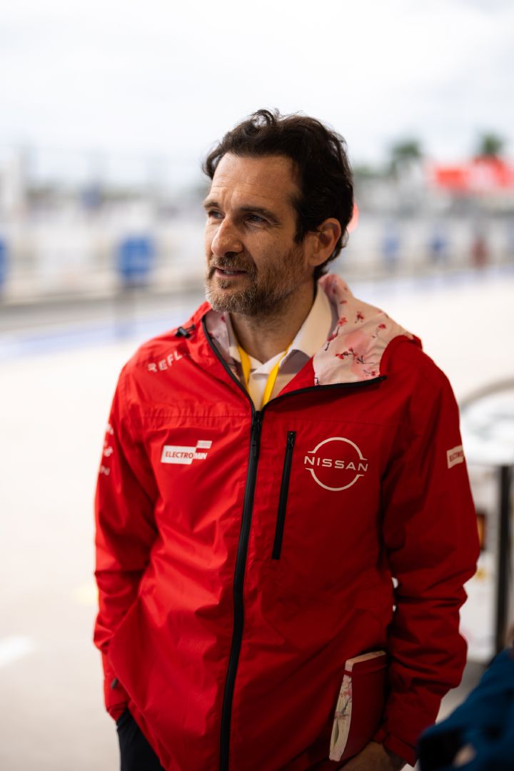 Porträtfoto von Tommaso Volpe in seiner roten Nissan Formula E Team-Jacke in der Teamgarage in Miami.