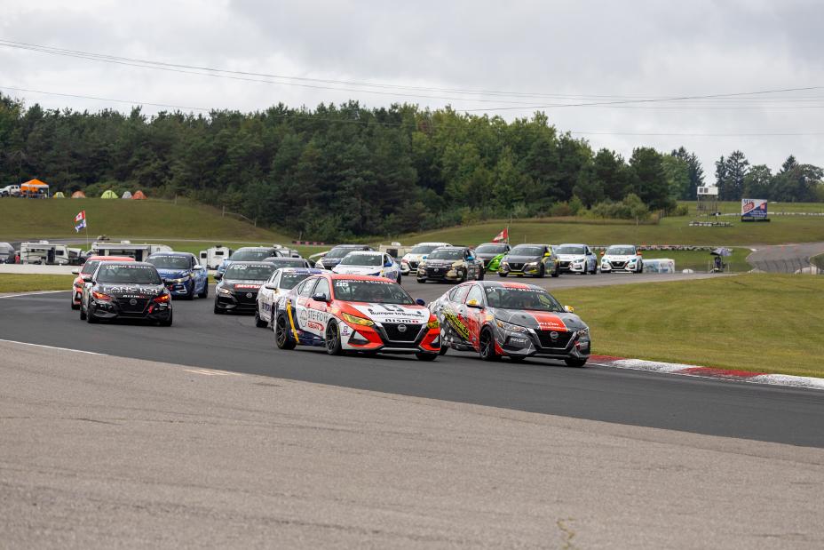 Nissan Sentra Cup race cars driving around the Canadian Tire Motorsport Park circuit with trees in the background