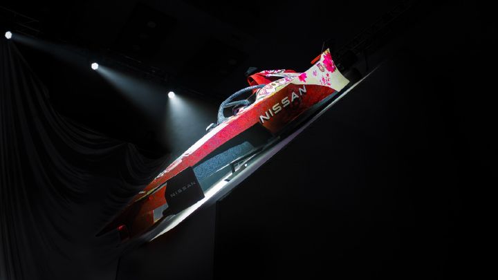 Carro da equipe Nissan de Fórmula E com nova pintura sendo iluminado com holofotes e um fundo preto