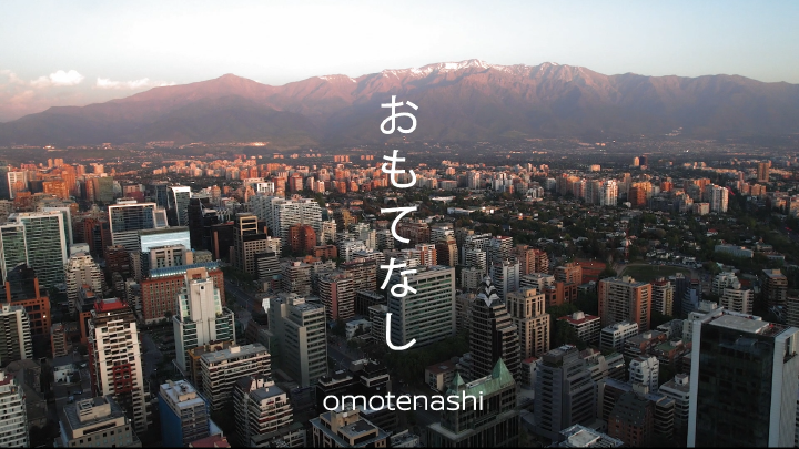Una ciudad de fondo y sobreimpresa la palabra omotenashi