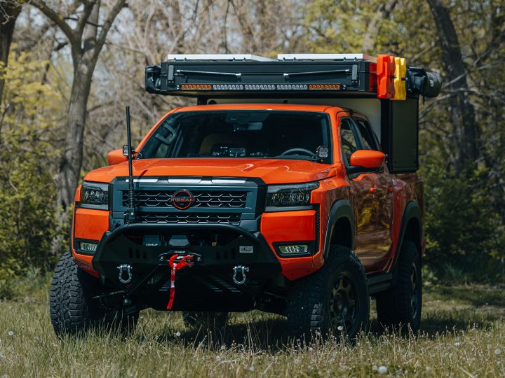 Angled view of a Nissan Frontier with multiple additions added on to the grill and truck bed.