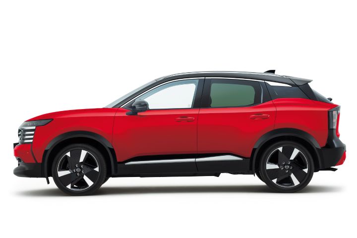Side view of a red Nissan Kicks. The vehicle faces right, with a black roof emphasizing the two-tone design.