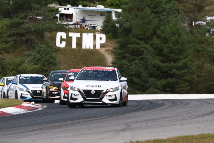 Group of Nissan Sentra Cup cars racing on the track.