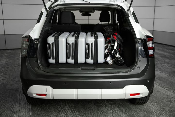 Three suitcases and a golf bag inside the trunk of the 2026 Nissan Kicks.