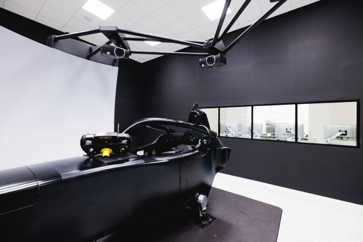 Seitliche Aufnahme des Nissan Formel E Rennsimulators mit Überwachungsbildschirmen im Hintergrund