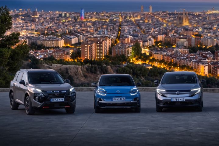 Les modèles Nissan électrifiés X‑Trail, Micra et LEAF sont alignés les uns à côté des autres, avec la Skyline de Barcelone en arrière-plan