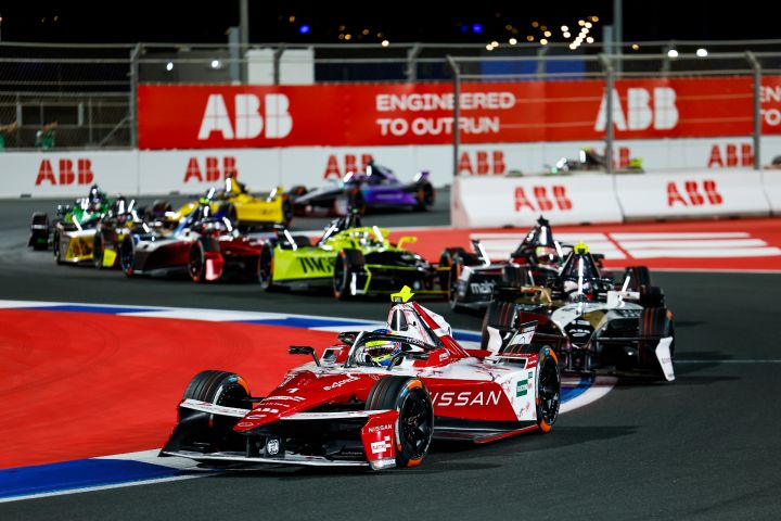 Frontalaufnahme von Oliver Rowland auf der Rennstrecke während des E-Prix von Dschidda, wo er den Nissan e‑4ORCE 05 mit der Startnummer 1 fährt, hinter ihm mehrere andere Fahrzeuge.