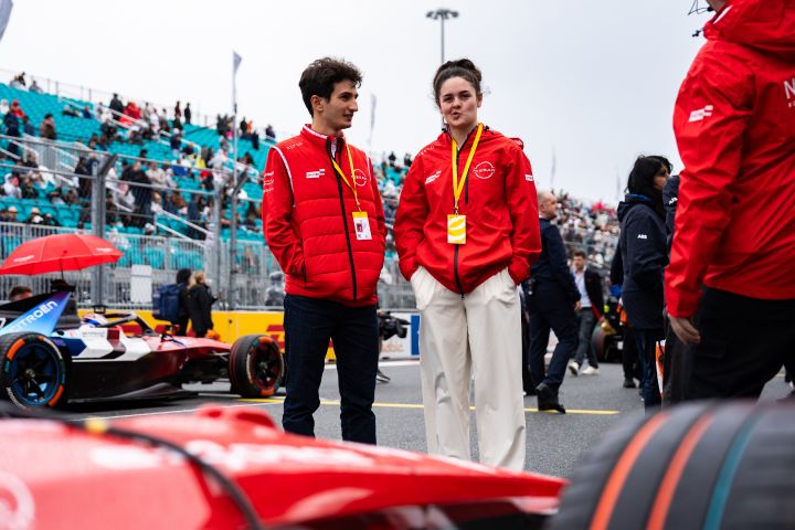 Abbi Pulling und Gabriele Mini stehen mit ihren roten Nissan Jacken zwischen den Rennwagen in der Startaufstellung vom Miami E-Prix