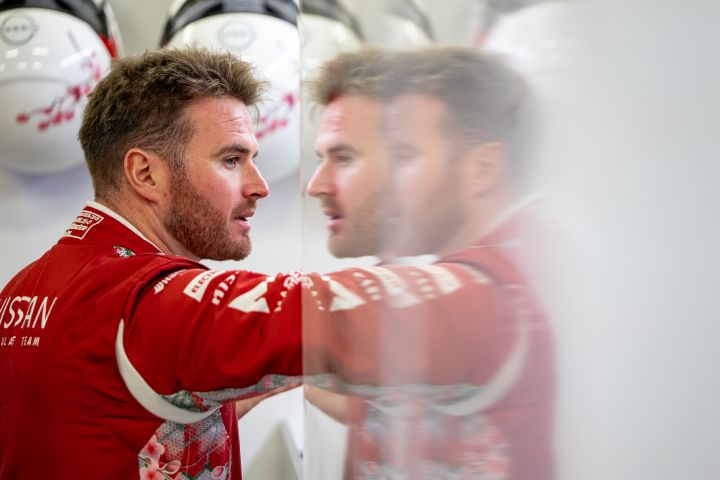 Oliver Rowland in der Garage, bekleidet mit seinem roten Rennanzug