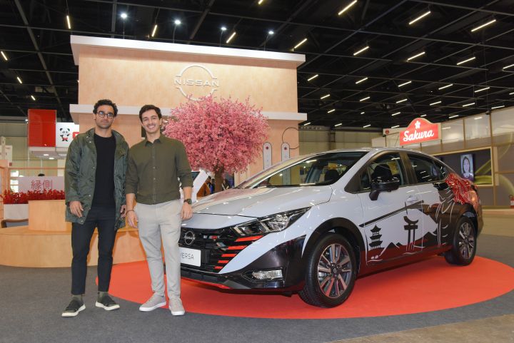 Designer da Nissan e estudante ao lado do carro personalizado no estande da Nissan no Festival do Japão