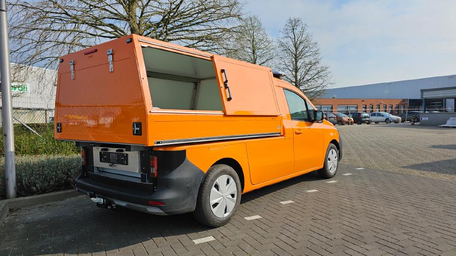 3/4 Heckansicht auf einen orangenen Nissan Townstar mit Kipper von Veth Automotive mit geöffneter Schiebetür am Aufbau