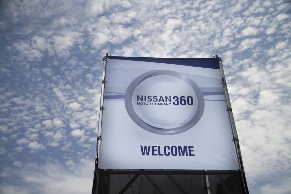 Vue du sol vers le ciel d'un panneau avec les mots Welcome Nissan 360 Motor company