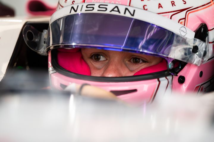 Abbi Pulling mit ihrem rosa Helm und hochgeklapptem Visier sitzt im Nissan e‑4ORCE 05 und wartet darauf, auf die Strecke zu gehen.