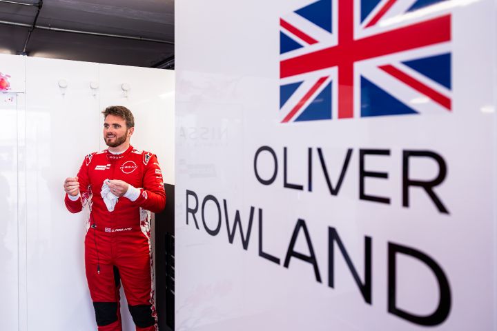 Oliver Rowland macht sich in seinem roten Rennanzug des Nissan Formula E Teams in der Teamgarage für eine Trainingseinheit bereit.