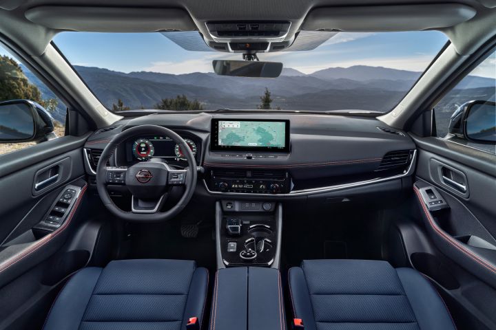 Der Innenraum des neuen 2026 Nissan X‑Trail verfügt über ein elegantes Armaturenbrett mit einem digitalen Kombiinstrument und einem zentralen Touchscreen, auf dem eine Navigationskarte angezeigt wird. Der Innenraum ist mit schwarzen Ledersitzen mit magmaroten Nähten, einem Multifunktionslenkrad und einem Panoramablick auf die Berge durch die Windschutzscheibe ausgestattet.