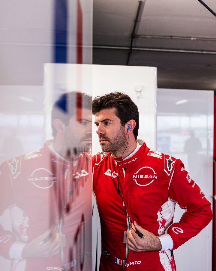 Porträtfoto von Norman Nato, der sich in seinem roten Rennanzug des Nissan Formula E Teams auf eine Session vorbereitet.