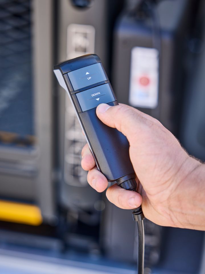 Eine Hand hält die Fernbedienung für den Rollstuhllift im Nissan Interstar-e mit MobiTEC Ausbau