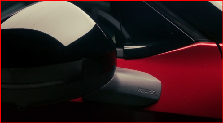 Imagem com fundo escurecido da parte inferior do retrovisor do novo Nissan Kicks onde está gravado “Kicks” na peça plástica