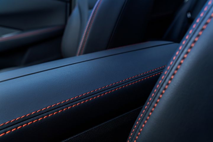 Der neue 2026 Nissan X‑Trail N-Trek – Nahaufnahme des Lederinnenraums mit detaillierten magmaroten Nähten an Armlehne und Sitz. Der Fokus liegt auf der Handwerkskunst und der hochwertigen Materialqualität im Fahrzeugdesign.