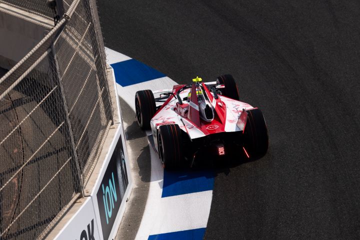 Rückansicht aus erhöhter Position von Oliver Rowland, der den Nissan e‑4ORCE 05 mit der Startnummer 1 über einen blau-weißen Bordstein in Dschidda fährt.