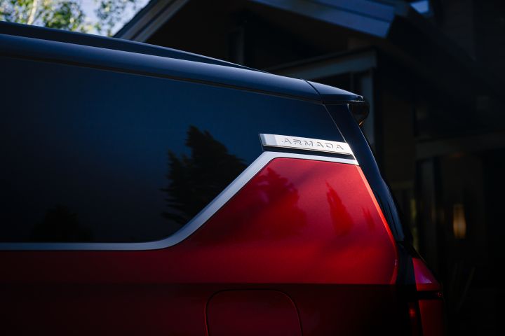 Close up of the top half of a red 2025 Nissan Armada, the Armada logo can be seen in the upper right.