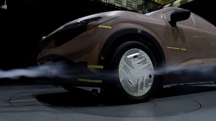 Blick von schräg unten auf die Front eines LEAF Tonmodells in einem Aerodynamik-Testtunnel, der Luftstrom läuft entläng der Fahrzeugkontur.