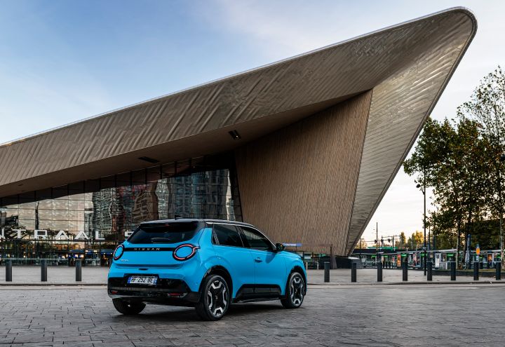 3/4-Heckansicht eines blauen Nissan Micra, der vor dem Rotterdamer Hauptbahnhof parkt