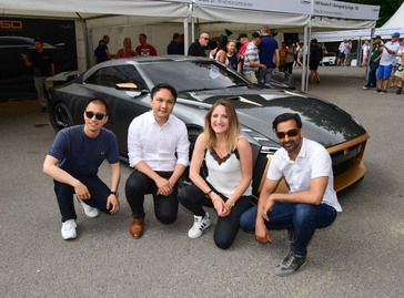 Four people down on one knee posing for a photo with the GT-R50