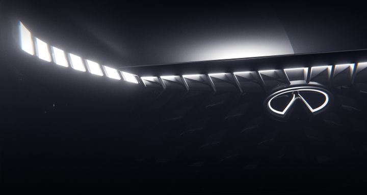 Close up of the grill on an INFINITI Concept, the headlights and emblem are illuminated.